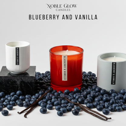 Three candles labeled 'Blueberry and Vanilla' surrounded by blueberries and vanilla beans on a light gray background.