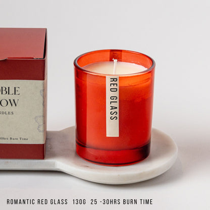 Red glass candle with 'Red Glass' label next to a box on a white surface